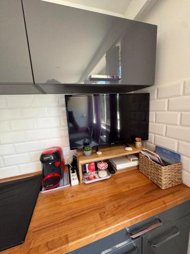 une télévision sur un comptoir en bois dans une cuisine dans l'établissement #COC Marina Baie des Anges - Studette, à Villeneuve-Loubet