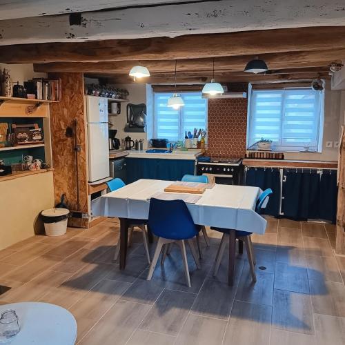 une cuisine avec une table blanche et des chaises bleues dans l'établissement Mon petit cocon jurassien, 