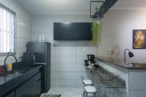 a kitchen with a sink and a refrigerator at Flórida vivo bem! in São Roque
