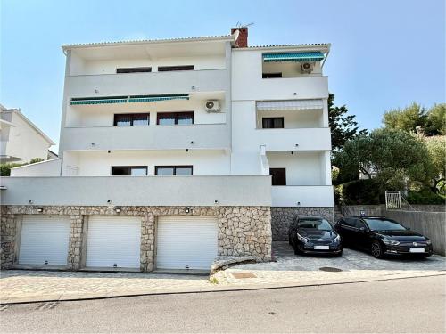 two cars parked in front of a white building at Nada in Krk