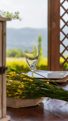 a wine glass sitting on top of a table with flowers at Il Borghetto di Carra in Talla