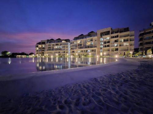 - un bâtiment sur la plage la nuit avec des lumières dans l'établissement Baia Kristal - Vacaciones Cartagena Colombia, à Carthagène des Indes