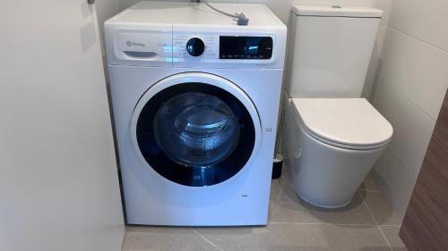 a washing machine in a bathroom next to a toilet at Recuncho Peña in Porto de Espasante