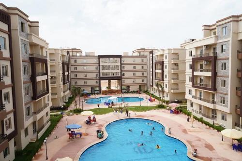 an aerial view of an apartment complex with a swimming pool at شاليه فندقي North coast قرية ومنتجع جوليانا أمام قرية قناة السويس - الساحل الشمالي juliana resort in Dawwār Muşādif Yūnus