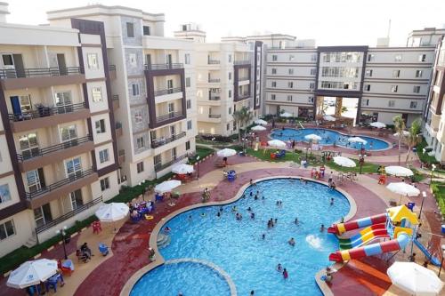 an aerial view of a swimming pool in a apartment complex at شاليه فندقي North coast قرية ومنتجع جوليانا أمام قرية قناة السويس - الساحل الشمالي juliana resort in Dawwār Muşādif Yūnus