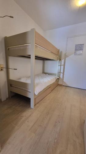 Ce lit superposé se trouve dans un dortoir doté de parquet. dans l'établissement Chez K&D by Antoine, à Saint-Raphaël