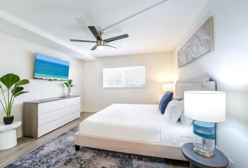 a bedroom with a bed and a ceiling fan at Coastal Escape Walk to Beach Pool and Gym in Boca Raton