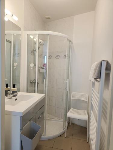 une salle de bain blanche avec une douche et un lavabo dans l'établissement Studio en hyper centre - à 250M de la plage de La Tranche, à La Tranche-sur-Mer