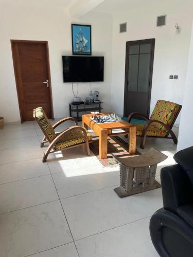a living room with a wooden table and chairs at La croix du sud in Lomé