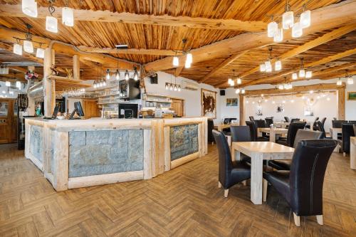 un ristorante con bar, tavoli e sedie di Ranč Podlesok a Hrabušice