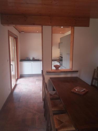 une cuisine et une salle à manger avec une table et des chaises en bois dans l'établissement Conjux - Maison entière - Lac du Bourget, à Conjux