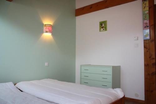 une chambre avec un lit blanc et une commode dans l'établissement Conjux - Maison entière - Lac du Bourget, à Conjux
