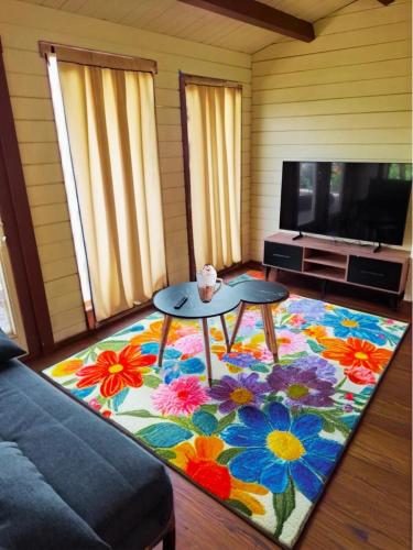 a living room with a table and a tv at The Heart Cabin in Kidmat Tsvi