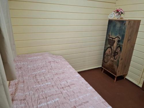 a room with a bed and a painting of a bicycle at The Heart Cabin in Kidmat Tsvi