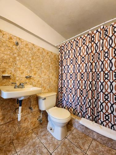 a bathroom with a toilet and a sink and a shower at Casa Robinson Guest House in Culebra