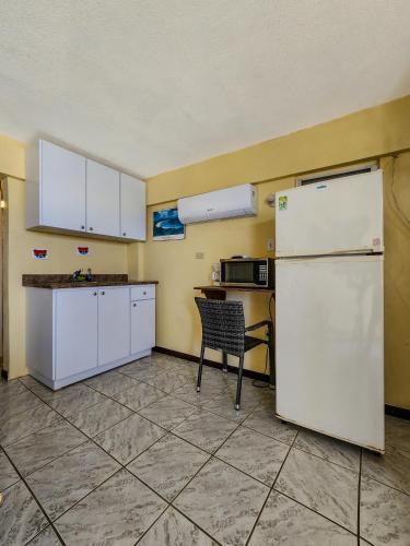 a kitchen with a white refrigerator and a chair at Casa Robinson Guest House in Culebra