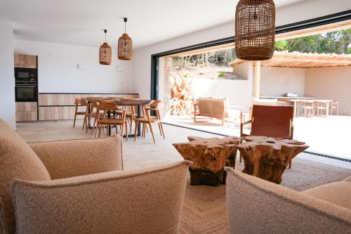 un salon avec des tables et des chaises et une grande fenêtre dans l'établissement Bergerie entre plage et maquis, à Zonza