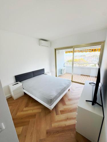 une chambre blanche avec un lit et une fenêtre dans l'établissement #S21 Chic Escape - Sea & Port View - Marina, à Villeneuve-Loubet