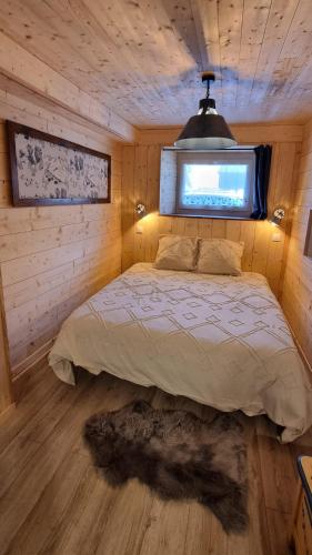 une chambre avec un lit dans une cabane en bois dans l'établissement Studio en Abondance, à Vacheresse