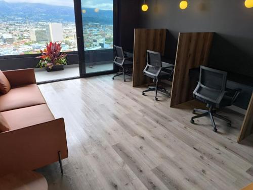 a waiting room with chairs and a couch and a window at Chic Studio in Barrio Escalante in Tapantí