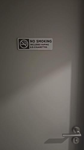a no smoking sign on a wall above a sink at Chic Studio in Barrio Escalante in Tapantí