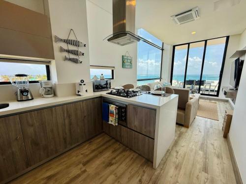a kitchen with a stove top oven next to a living room at Almare Apartamentos nuevos in Gustavo Rojas Pinilla International