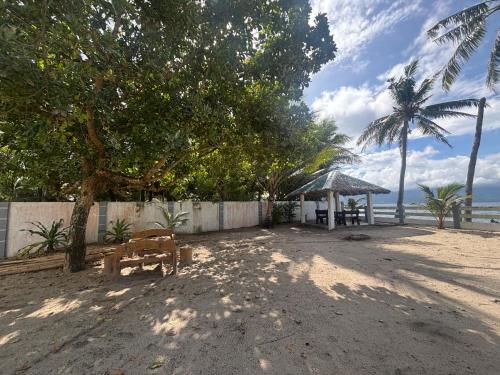 a bench on the beach with a table and a tree at Lui my happy place in Pandan