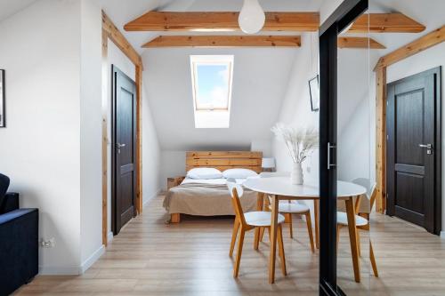 a bedroom with a bed and a table and chairs at Willa Atena in Łeba
