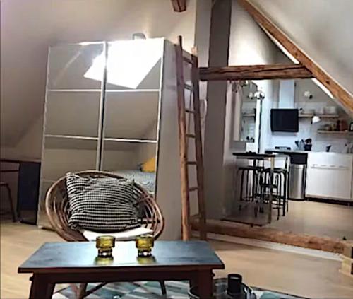 un salon avec une table et un réfrigérateur dans l'établissement Le Cosy d'Asfeld, à Metz