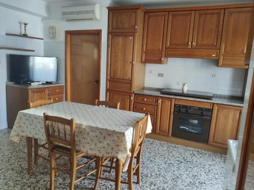 a kitchen with a table and some wooden cabinets at Casa vacanze Giada in Peschici