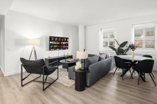 ein Wohnzimmer mit Sofa, Tisch und Stühlen in der Unterkunft Stylish NYC Haven Steps to Broadway & Dining in New York