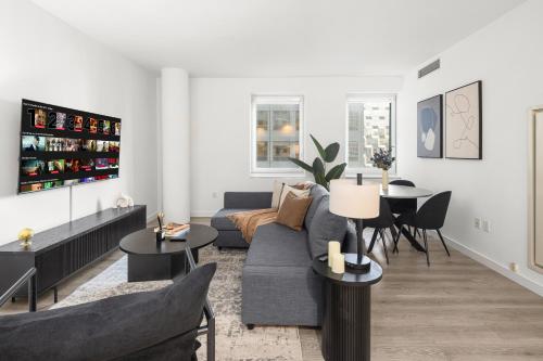 a living room with a blue couch and tables at Stylish NYC Haven Steps to Broadway & Dining in New York