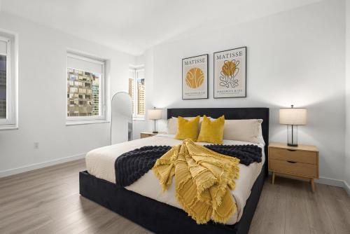 ein Schlafzimmer mit einem großen Bett mit gelben Kissen in der Unterkunft Stylish NYC Haven Steps to Broadway & Dining in New York