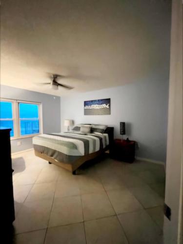 a bedroom with a bed and a large window at Quiet direct oceanfront 2 bed 2 bath condo w/pool in Ormond Beach