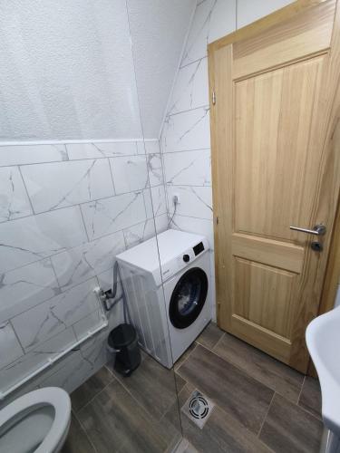 a washing machine in a bathroom next to a door at Holiday chalet Asterix in Žabljak
