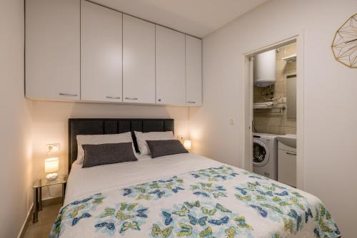 a bedroom with a large bed with white cabinets at Studio Apartment Nikol in Split