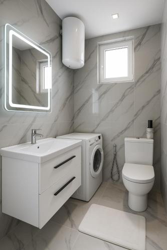a white bathroom with a washing machine and a sink at Eron Villas Velipoje in Velipojë
