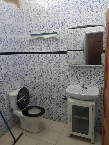 a bathroom with a toilet and a sink at Villa Privée in Abomey-Calavi