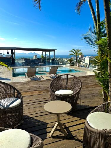 a deck with chairs and tables and a swimming pool at RARO Ipanema Boutique Hotel in Rio de Janeiro