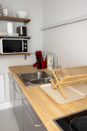 a kitchen counter with a sink and a microwave at Appartement dijk Middelkerke met zeezicht in Middelkerke