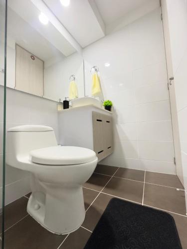 a white bathroom with a toilet and a sink at Apartamento punto céntrico in Ibagué