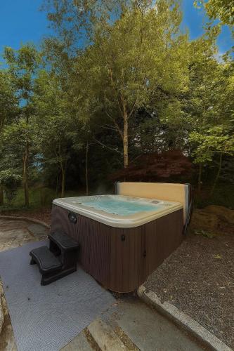 a jacuzzi tub in a yard with a stool at Bluebell Cottage - with hottub in Newry