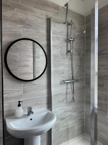a bathroom with a sink and a mirror at Bright East Dulwich Apartment in London