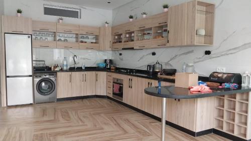 a kitchen with wooden cabinets and a table in it at Villa privé Tetouan avec piscine in Tetouan