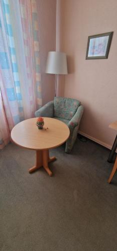 a room with a table and a chair and a couch at Hotel-Restaurant Wilhelmsbad in Seesen