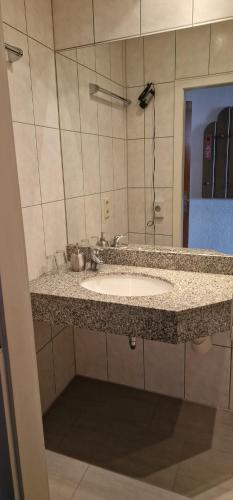 a bathroom counter with a sink and a mirror at Hotel-Restaurant Wilhelmsbad in Seesen