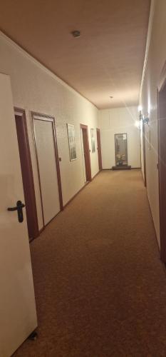 an empty hallway of a building with doors and carpet at Hotel-Restaurant Wilhelmsbad in Seesen