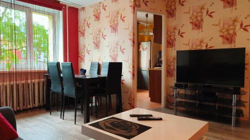 a living room with a table and a flat screen tv at Seebi-apartment in Tallinn
