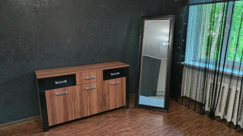 a mirror and a wooden cabinet with a dresser and a dresser with at Seebi-apartment in Tallinn