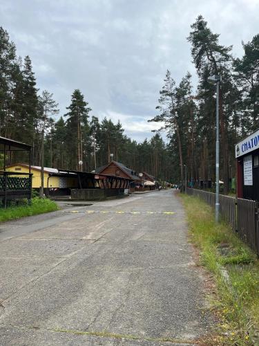 an empty road next to a building and a fence at Chata Veverka in Doksy